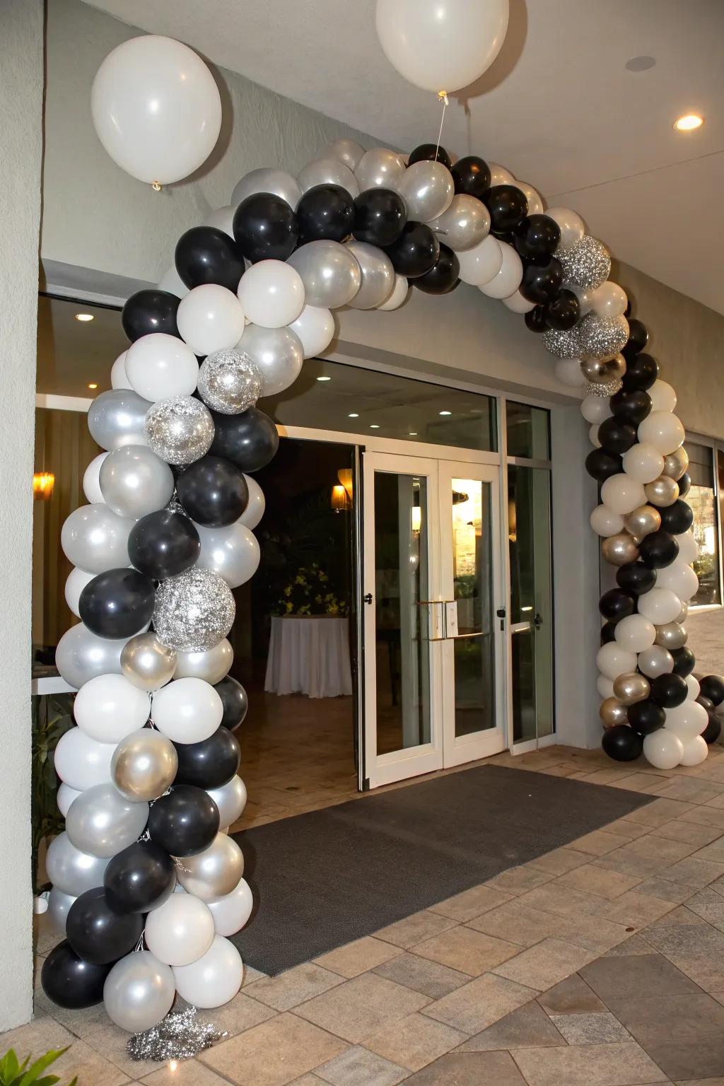 An elegant balloon cascade in shades of black, silver, and white.