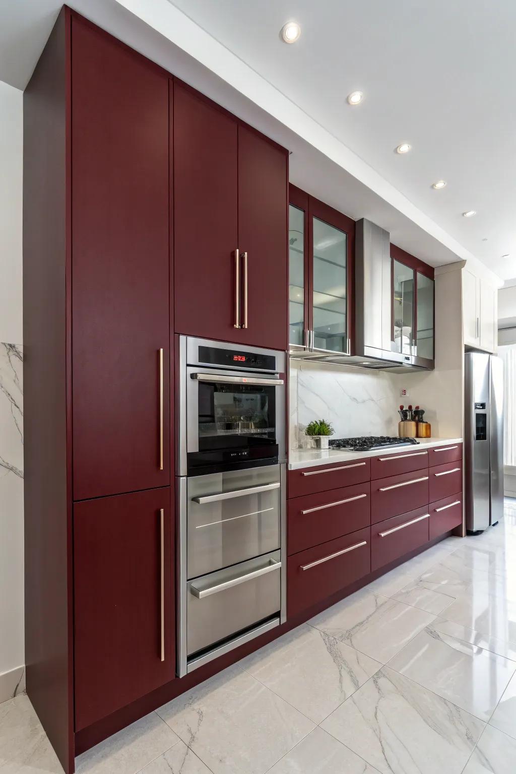 Minimalist kitchen design with handle-less dark red cabinets.