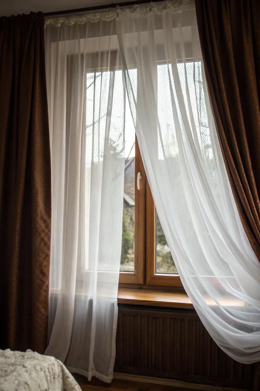 Delicate sheer and privacy drapes create a warm, secluded bedroom atmosphere.
