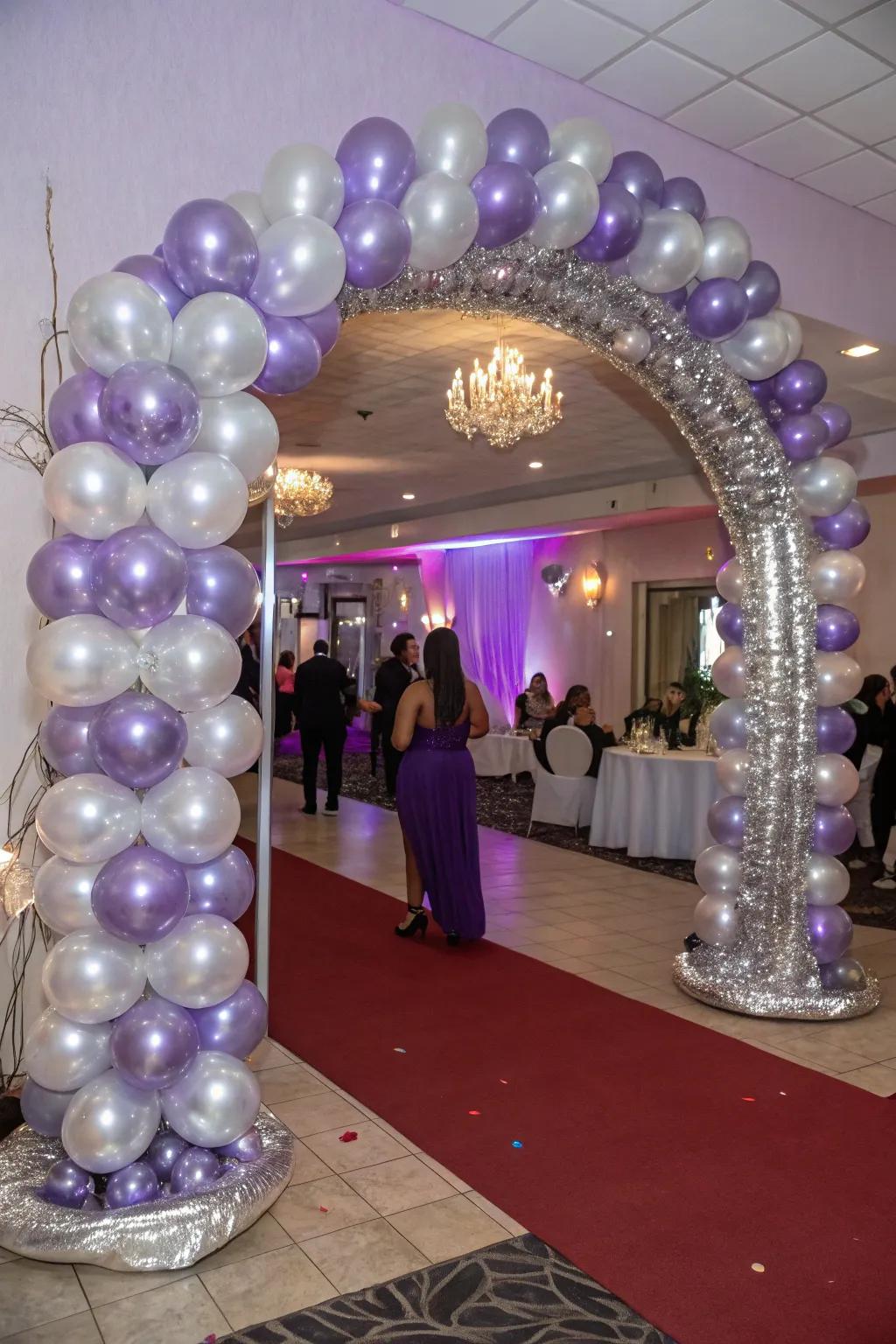 A striking entrance featuring an amethyst and silver balloon arch, warmly welcoming guests.