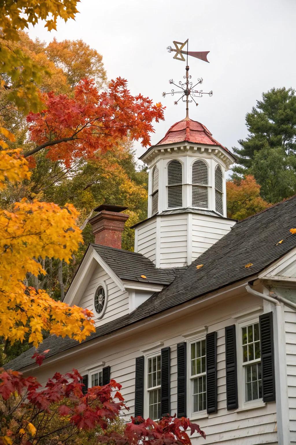 A majestic Colonial residence elevated by a wooden cupola and traditional weathervane.
