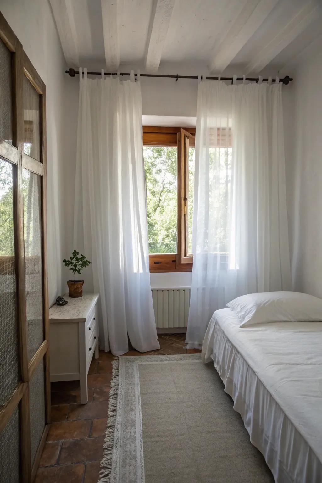 White curtains help make this small bedroom feel larger.