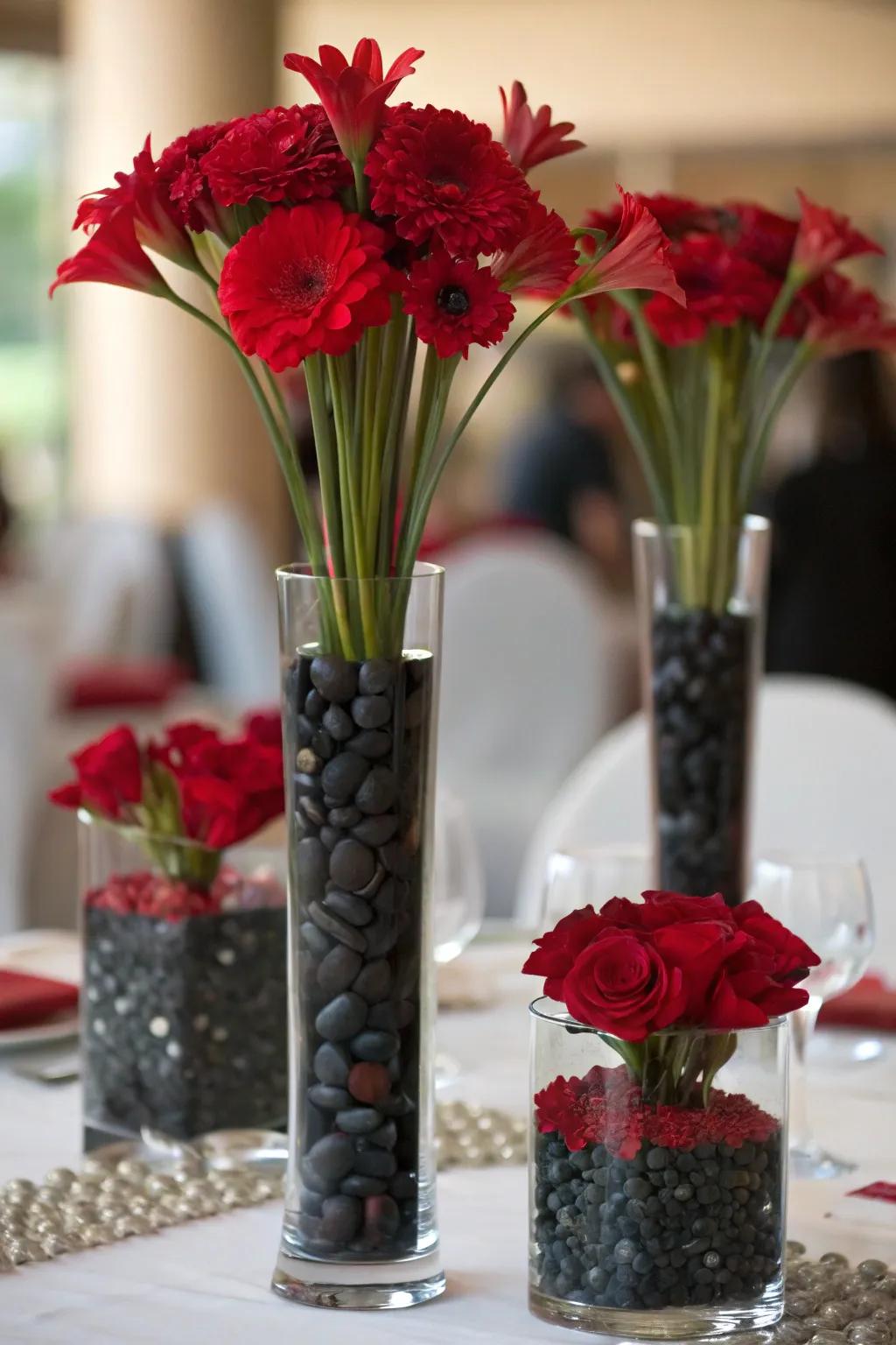 Containers featuring differing altitude ranges, filled using scarlet flowers also charcoal pebbles to offer depth.