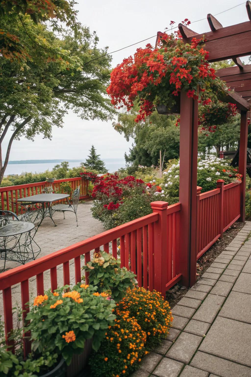 A scarlet fence provides a vibrant backdrop for patio plants.