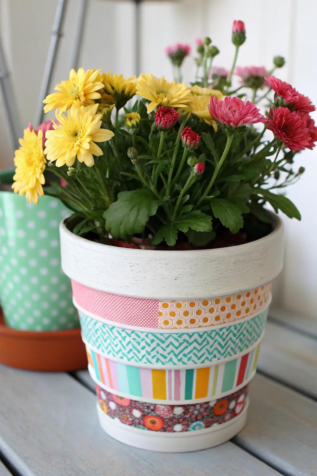 A flower pot enhanced with vibrant decorative adhesive ribbon designs.