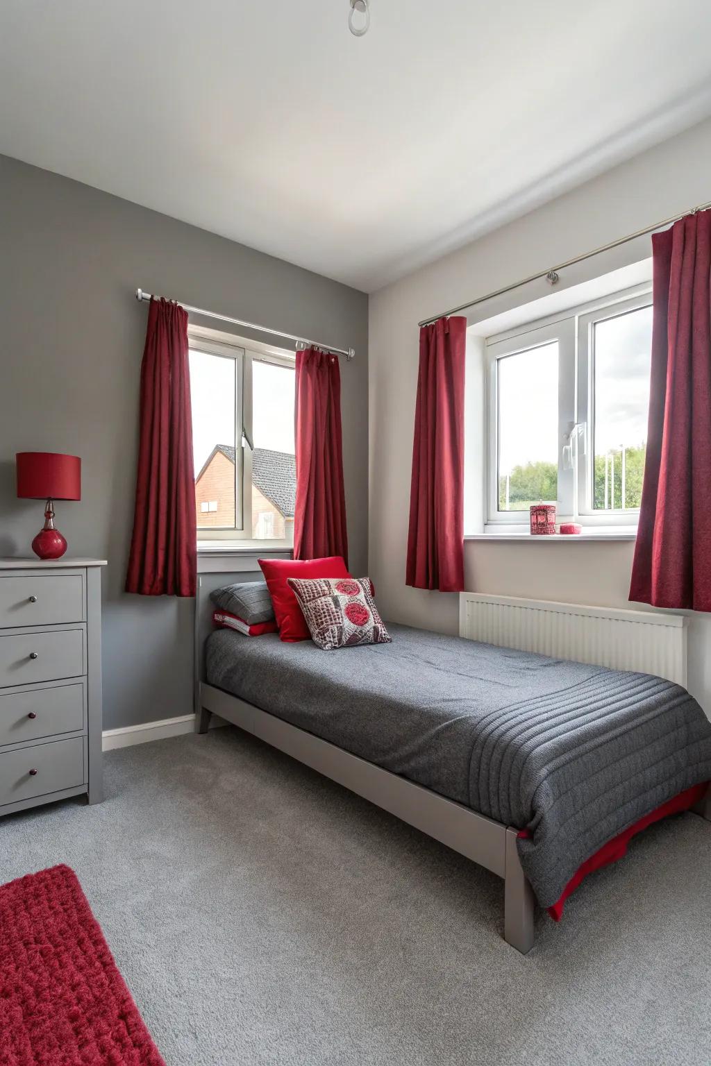 A minimalistic approach in a small bedroom with select red and grey decor pieces.