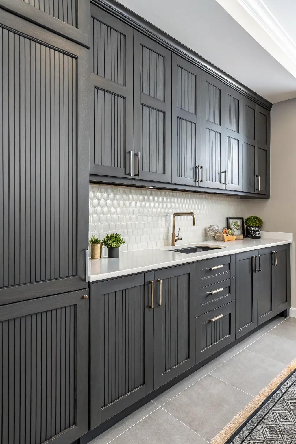 Vertical impressions adding texture and height to the deep charcoal cabinets.