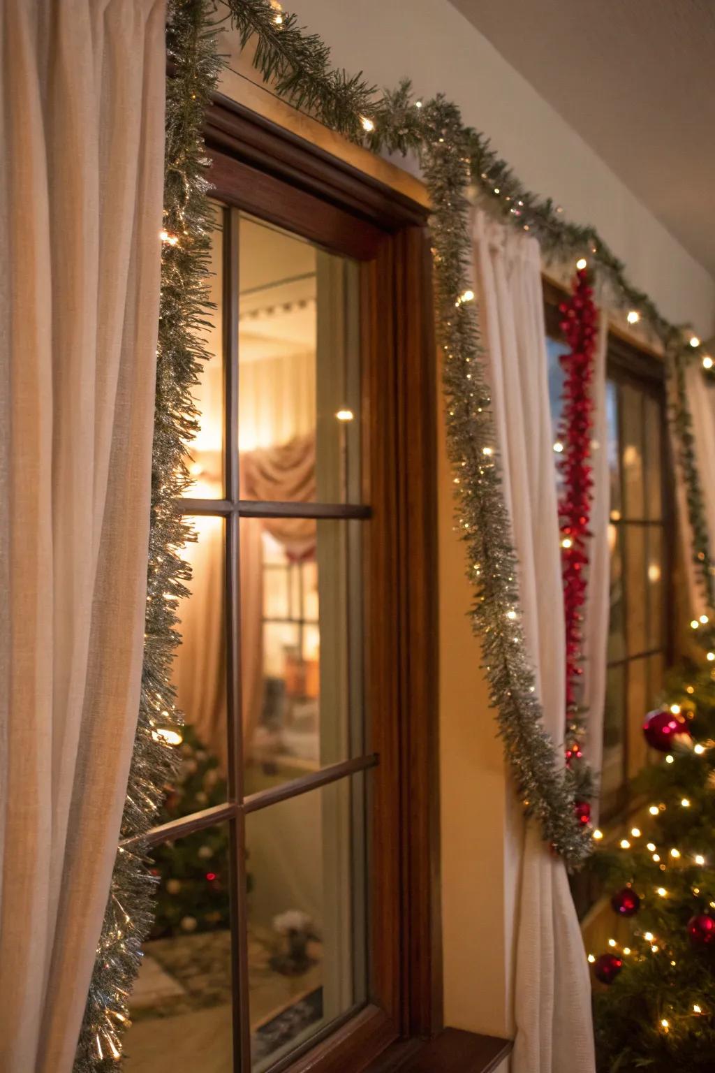 A window enhanced with tinsel garland hanging from the curtain rods.