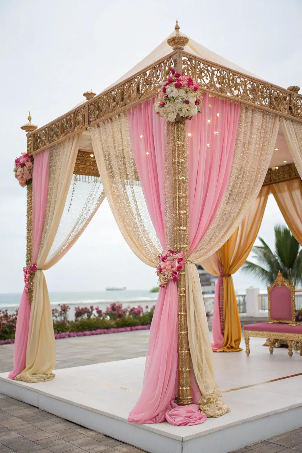 Luxurious draped fabrics in gold and pink enveloping a mandap.