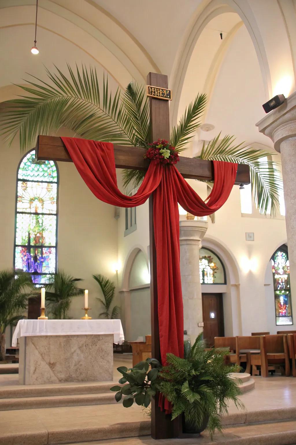 A cross decorated with scarlet fabric and palms, signifying Palm Sunday.