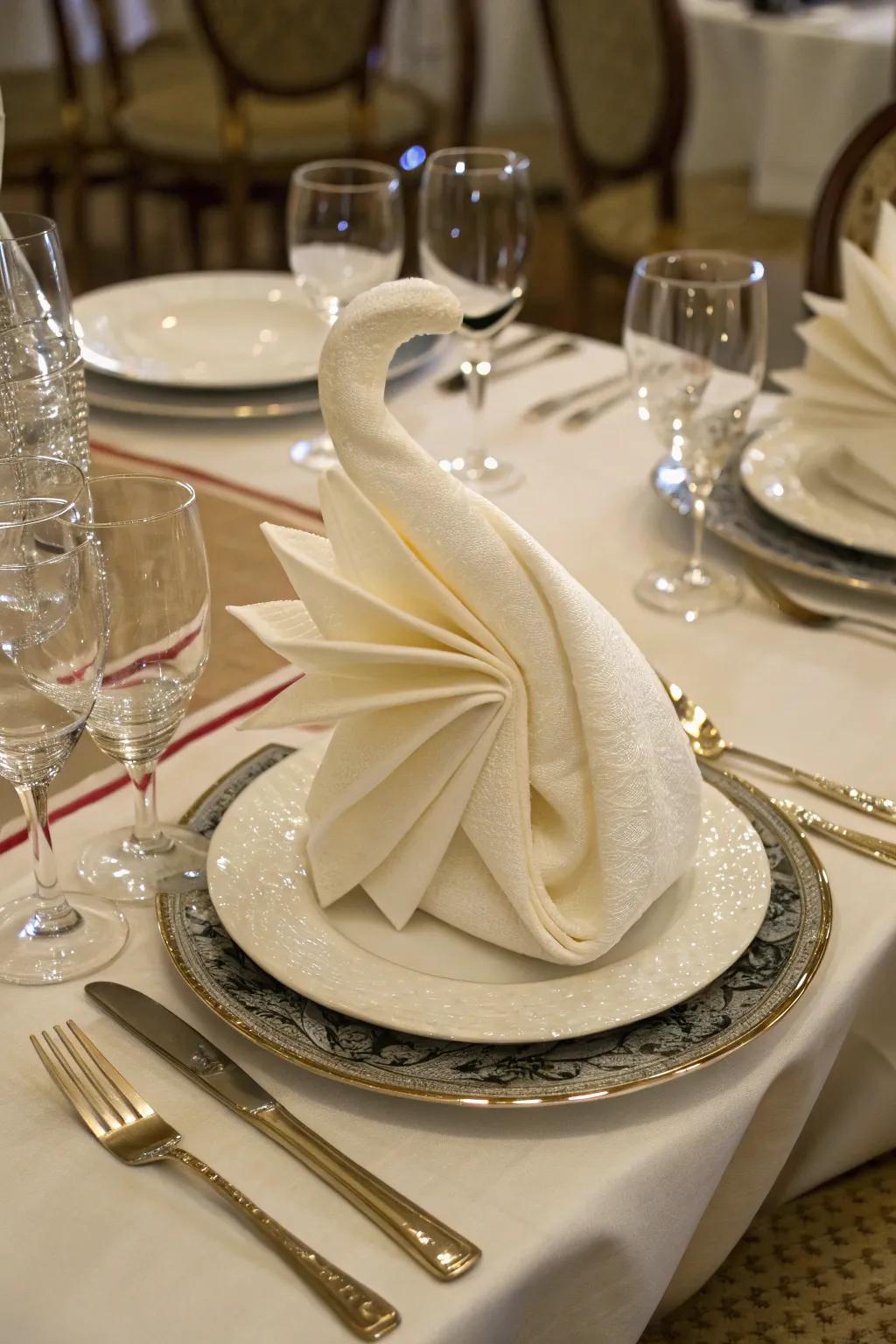 A swan napkin fold adds a touch of elegance to any dinner.