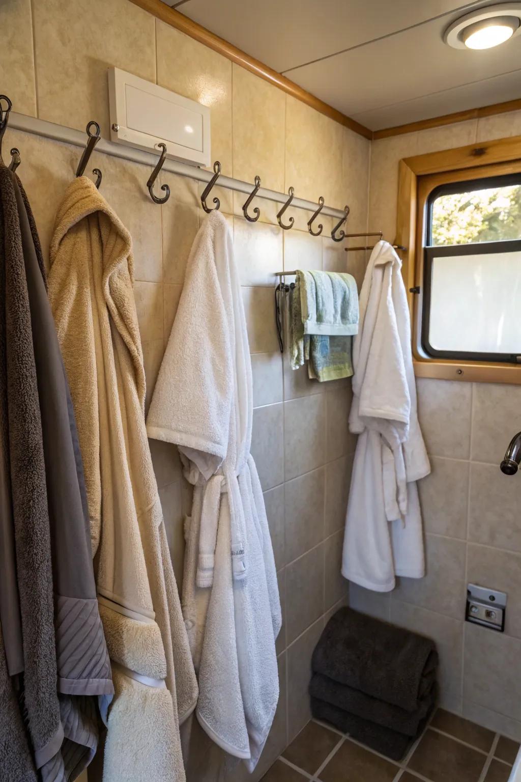 Pegs making it easy to grab towels and robes in a camper bathroom.