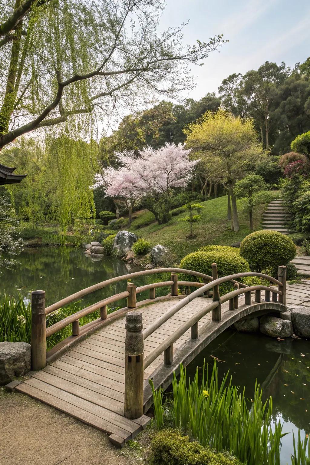 A rustic wooden bridge arches over a pond within a Japanese garden.