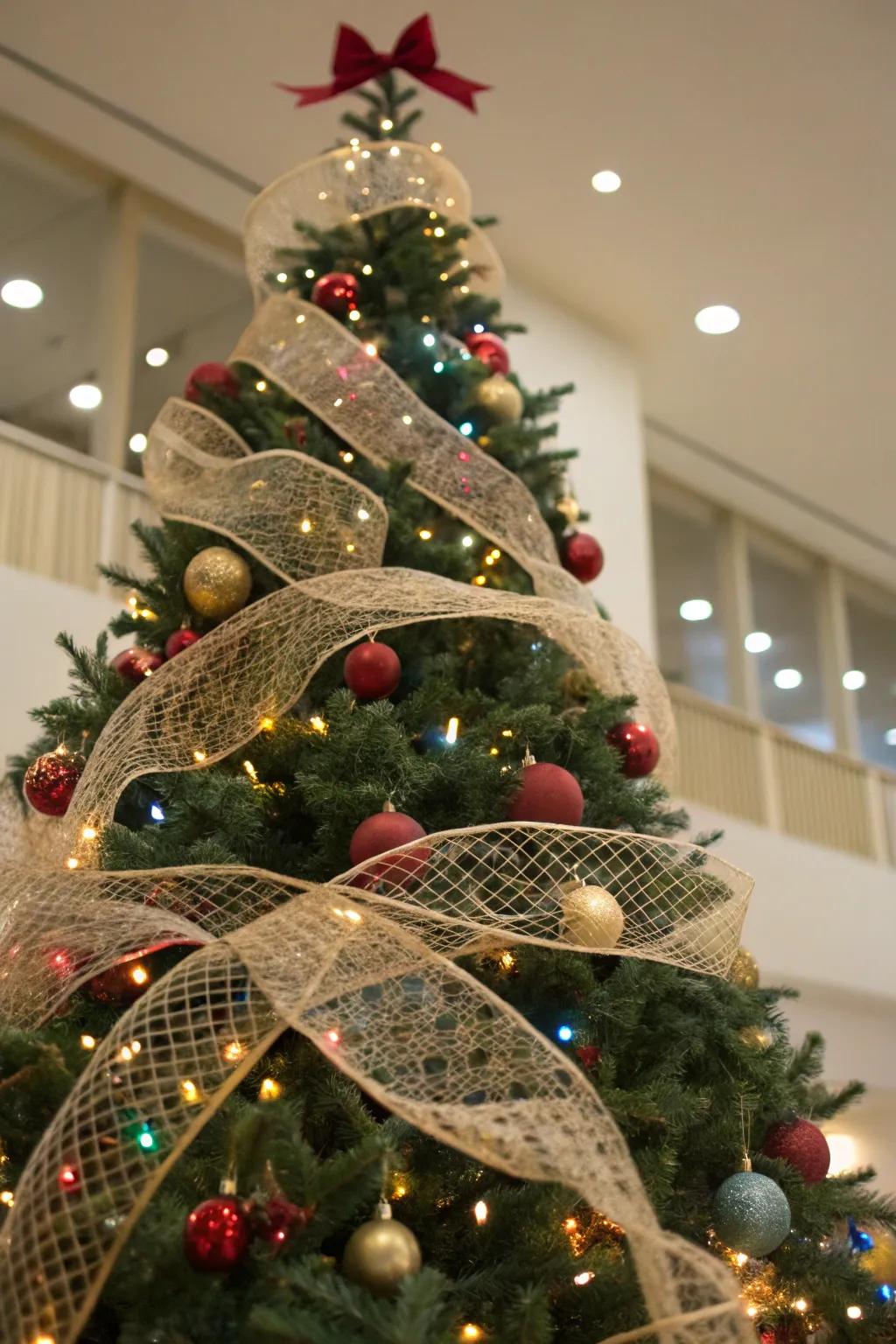 A Christmas tree featuring mesh ribbons woven throughout the branches, imparting texture and dimension.